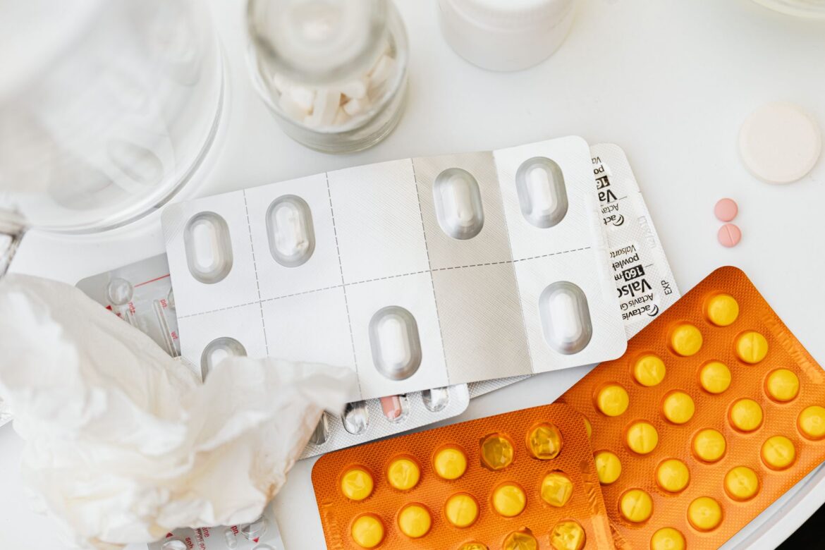 A collection of various medicine blister packs and pills arranged on a white surface, ideal for healthcare themes.