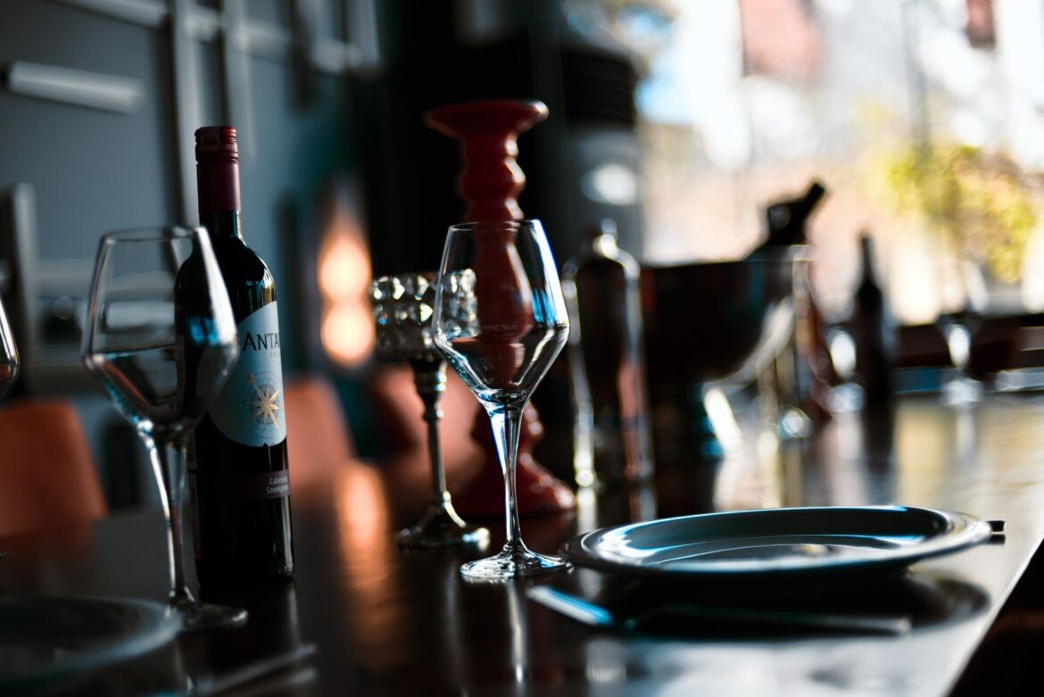 A sophisticated indoor wine setting with glasses, a bottle, and warm lighting.
