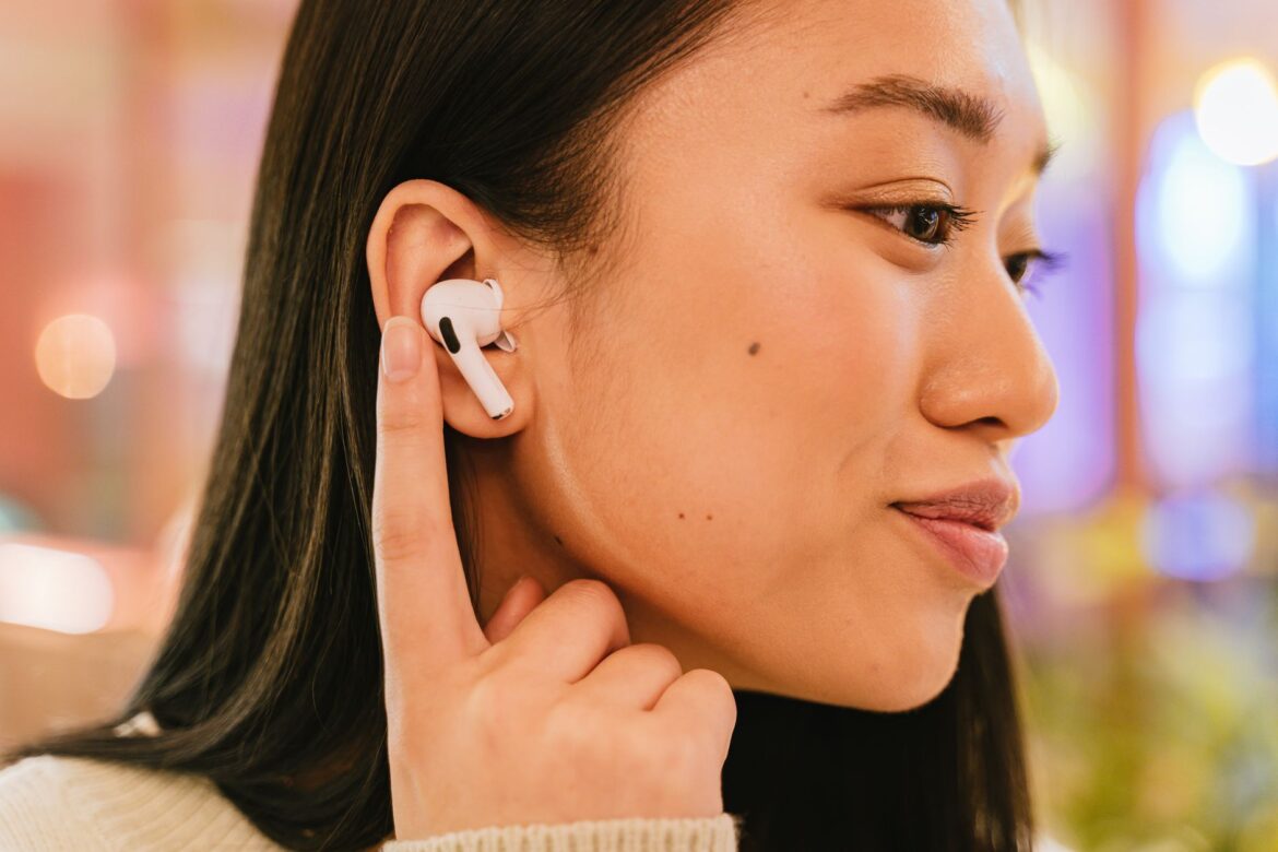 A woman wearing wireless earbuds, focusing on her listening experience.